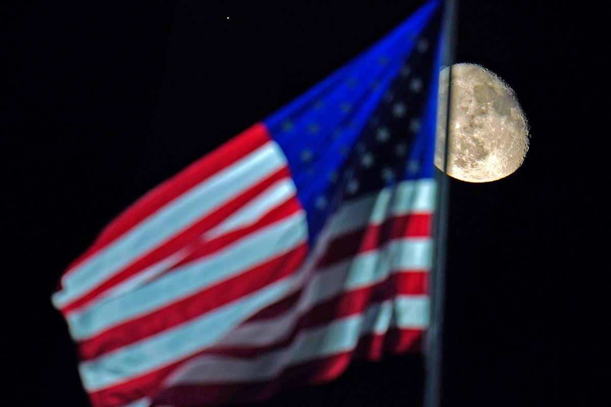 The waning gibbous moon rises, with a U.S. flag flying over PNC Park in the foreground during a baseball game between the Pittsburgh Pirates and the Cincinnati Reds in Pittsburgh, Saturday, Sept. 5, 2020.