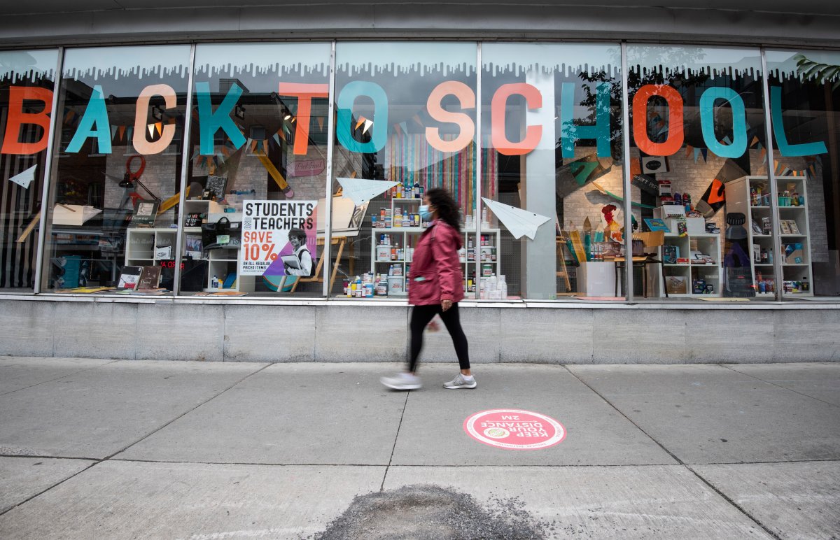 A person walks past a storefront advertising a back-to-school sale in Ottawa on the Labour Day Long Weekend, Monday, Sept. 7, 2020, in the midst of the COVID-19 pandemic. 