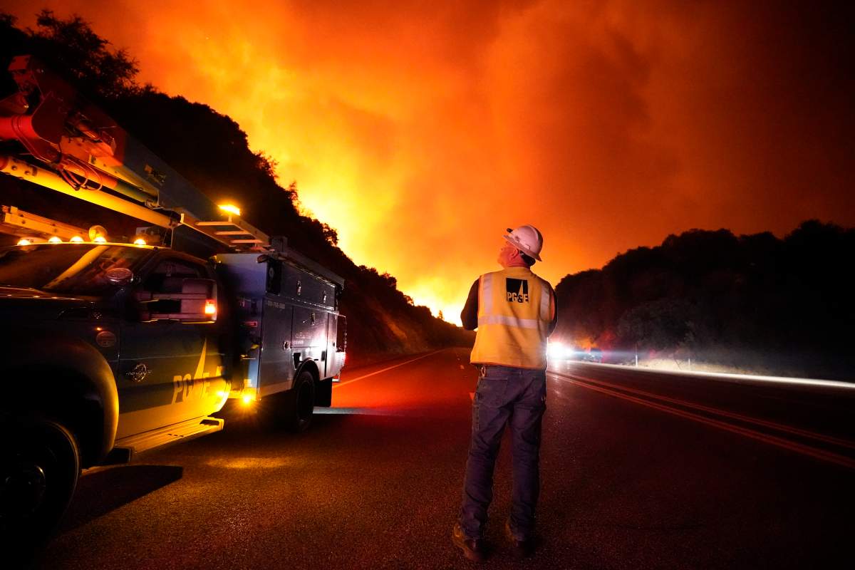 A Pacific Gas and Electric worker looks up at the advancing Creek Fire along Highway 168 Tuesday, Sept. 8, 2020, near Alder Springs, Calif. Smoke from the fires aren't expected to cause problems in Manitoba.