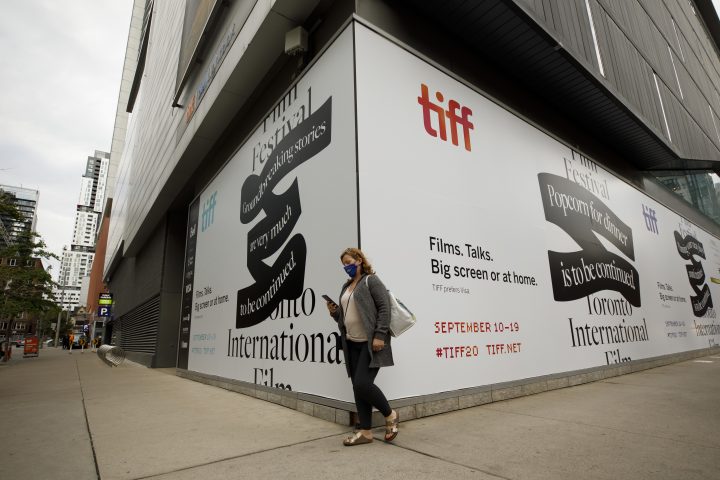 A person walks past the Toronto International Film Festival's TIFF Bell Lightbox theatre on King St., in Toronto, ahead of the festival's opening night, Thursday, Sept. 10, 2020. Netflix and the Toronto International Film Festival have been an inseparable power couple for years, mastering the ways to get moviegoers talking, but during the pandemic their storied Hollywood relationship is on a break.