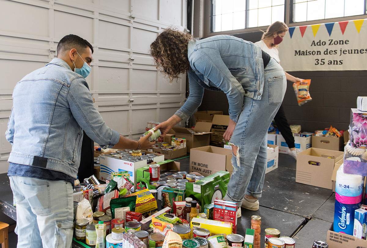 Volunteers sort through donated food items and other sundries during the ‘September 13th Miracle’ food drive in Montreal, Sunday, Sept. 13, 2020. 