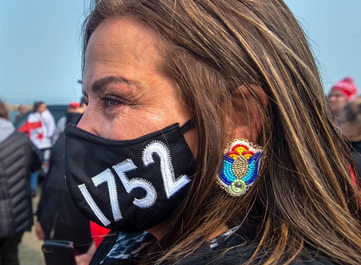 A woman wears a face mask honouring the Treaty of 1752 as members of the Sipekne'katik First Nation and others attend a ceremony on the wharf in Saulnierville, N.S., to bless the fleet before it launches its own self-regulated fishery on Thursday, Sept. 17, 2020.