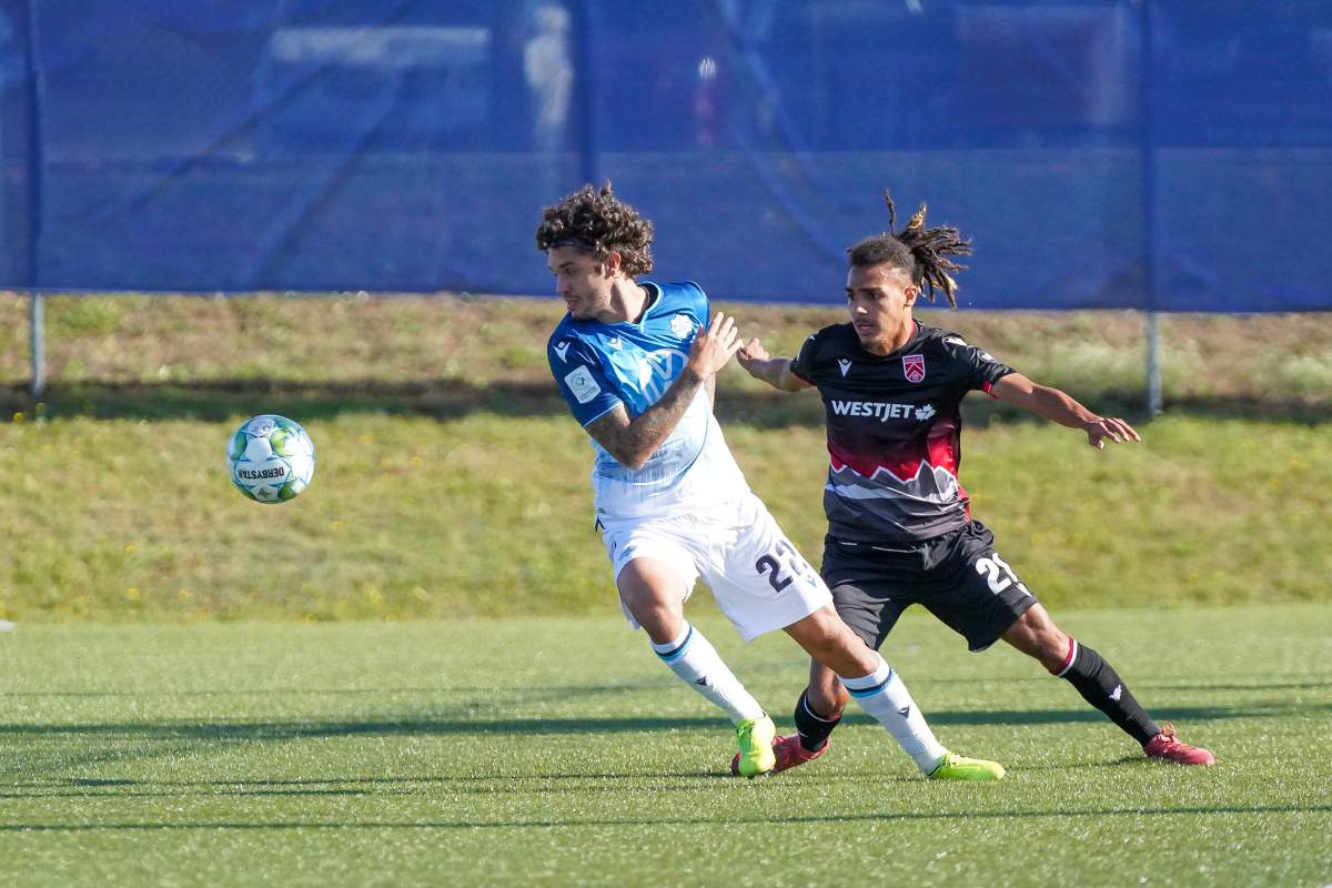 HFX Wanderers player Joao Morelli fights off Calvalry FC’s Mohamed Farsi during a match on Sept. 12, 2020.