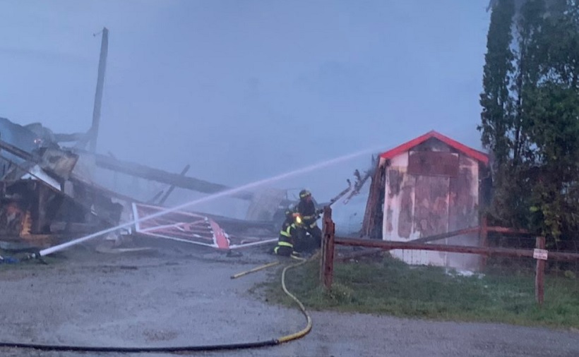 Firefighters pour water on a building at the Woodstock Fairgrounds Tuesday evening.