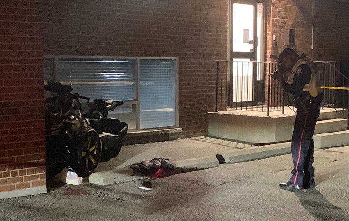 Toronto police photograph a motorcycle at the side of a building Thursday evening.