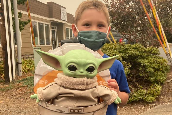 Carver Tinning, 5, is shown with the Baby Yoda toy he donated to firefighters in Oregon.