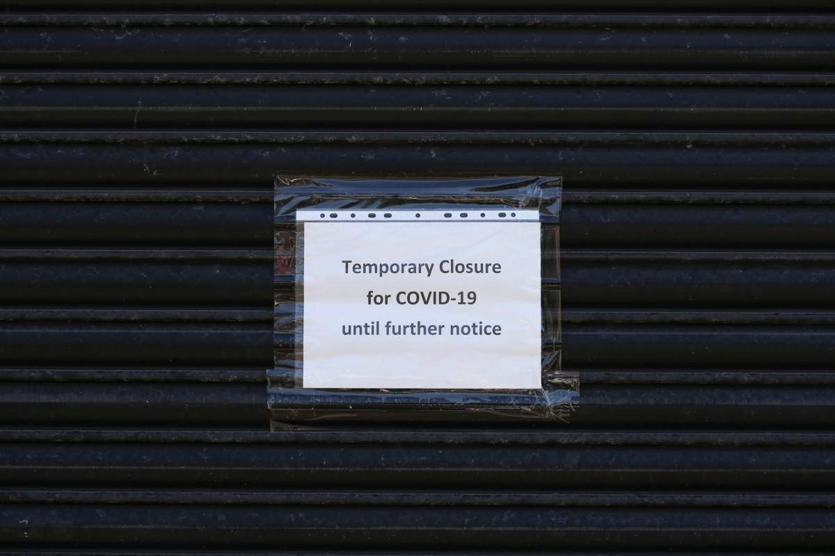 A sign on a shuttered building saying 'Temporary closure for COVID-19’ during the coronavirus pandemic.