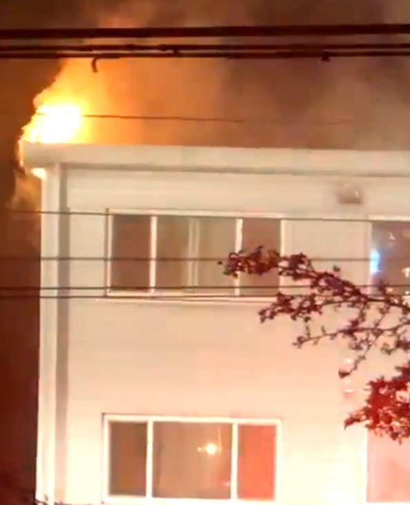 Vancouver fire crews enter the top floor corner suite of a two-storey residential building on Granville Street and West 70th Avenue, where flames can be seen shooting from the roof Thursday evening.
