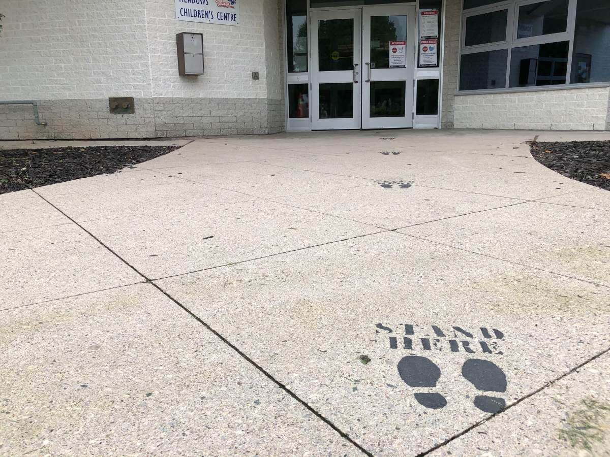 Physical distancing signage placed outside of Bonaventure Meadows intended to keep space between those waiting to come inside.