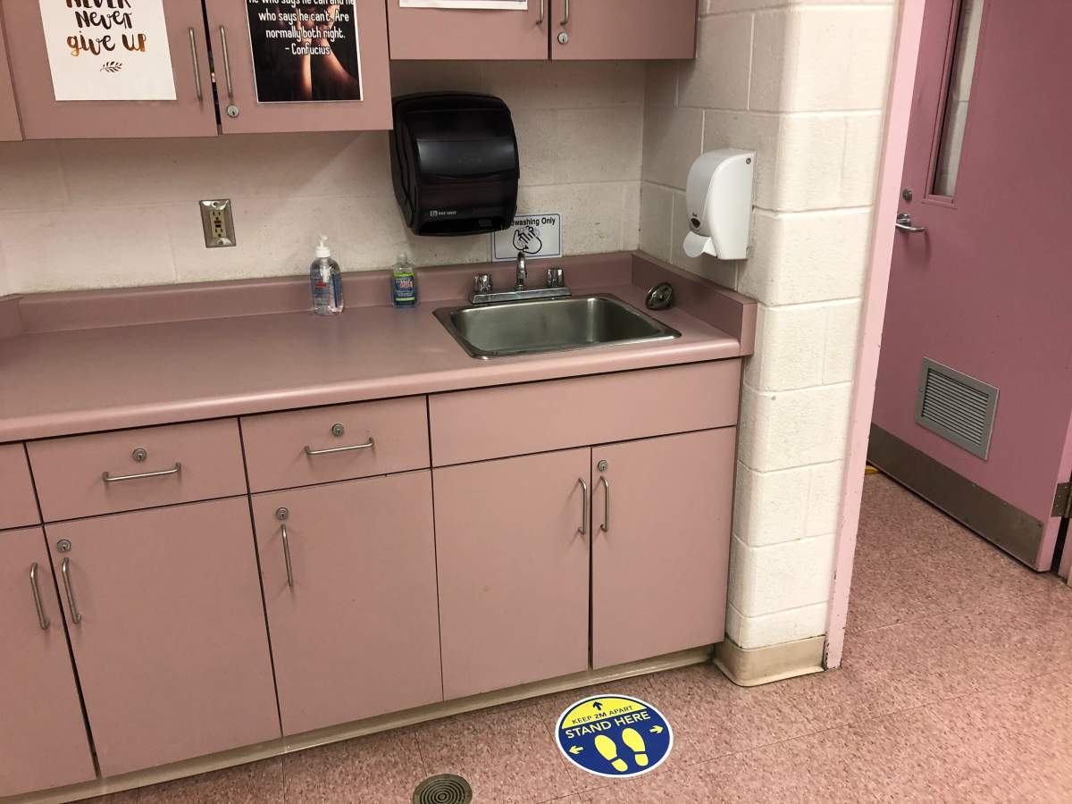 A sink complete with physical distancing signage inside a Grade 2/3 split class at Bonaventure Meadows.