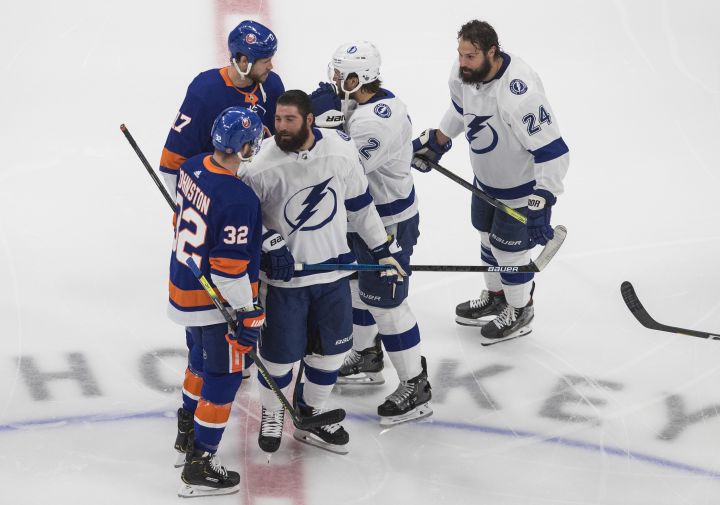 Tampa Bay Lightning's Pat Maroon (14), Luke Schenn (2) and Zach Bogosian (24) have words with New York Islanders' Ross Johnston (32) and Matt Martin (17) during warm up before NHL Eastern Conference final playoff action in Edmonton on Sunday, Sept. 13, 2020. 
