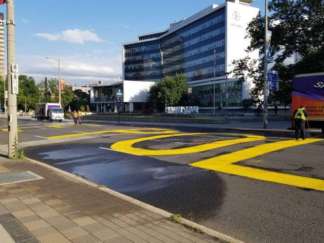 Demonstrators painted Defund The Police across Main St., prior to a Hamilton Police Board meeting on July 23.