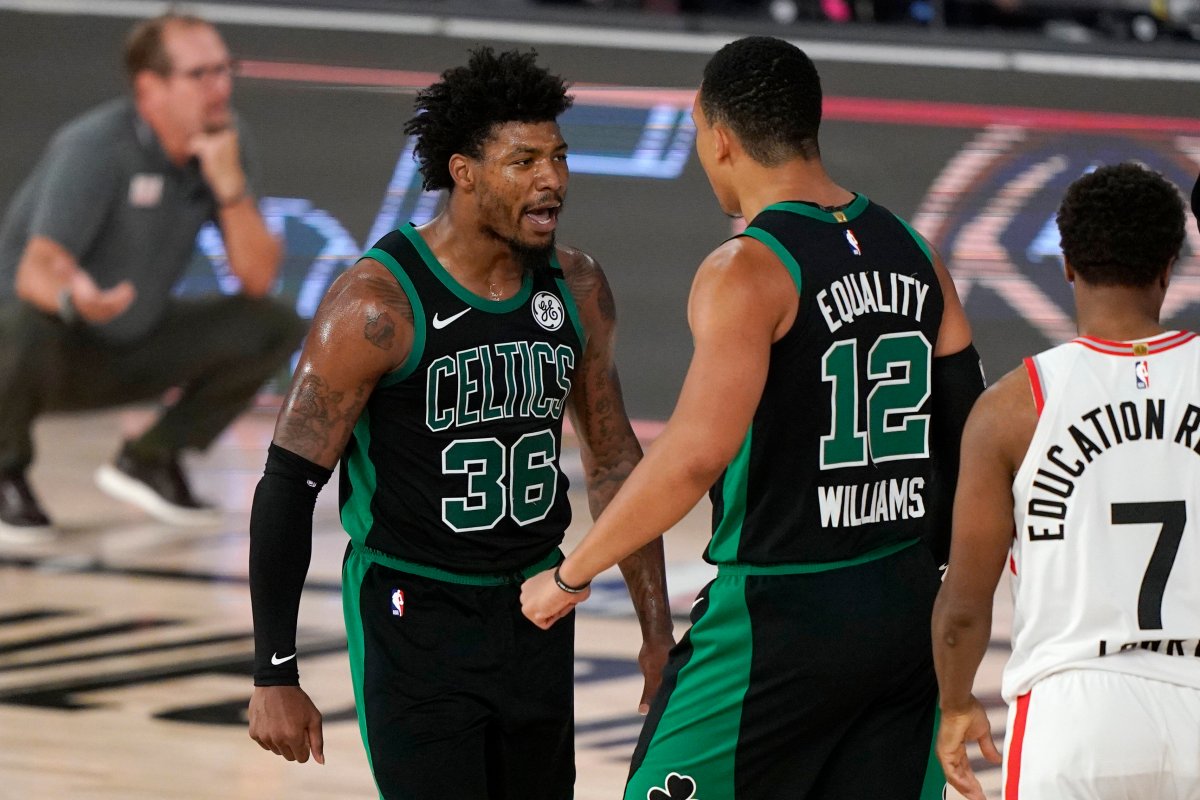 Boston Celtics' Marcus Smart (36) celebrates with Grant Williams (12) after sinking a basket and drawing a foul in the second half of an NBA conference semifinal playoff basketball game as Toronto Raptors' Kyle Lowry looks on Tuesday, Sept. 1, 2020, in Lake Buena Vista, Fla.