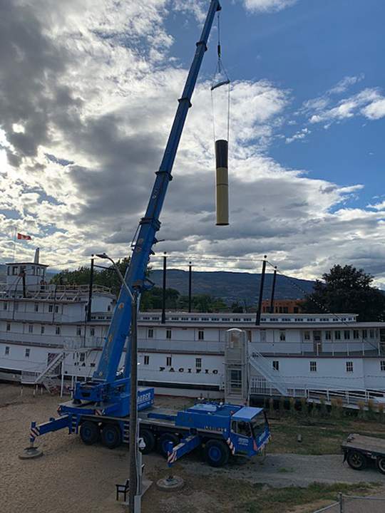 A crane hoisting the new smokestack to be installed on the S.S. Sicamous in Penticton.