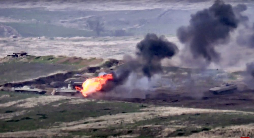In this image taken from a footage released by Armenian Defense Ministry on Sunday, Sept. 27, 2020, Armenian forces destroy Azerbaijani military vehicle at the contact line of the self-proclaimed Republic of Nagorno-Karabakh, Azerbaijan.  (Armenian Defense Ministry via AP)