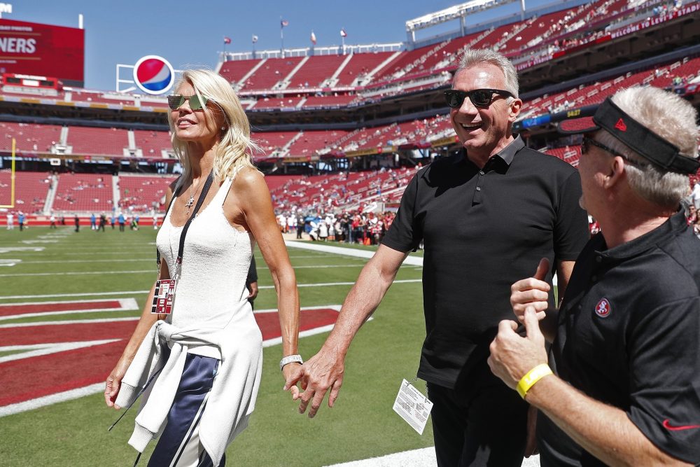 In this Sept. 16, 2018, file photo, Joe Montana and his wife, left, Jennifer walk onto the field at Levi's Stadium before an NFL football game between the San Francisco 49ers and the Detroit Lions in Santa Clara, Calif. 