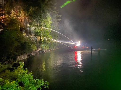 A Vancouver fire boat assists with the firefight as flames scorch the forest in the Woodlands area of Deep Cove near the waterfront Wednesday night.