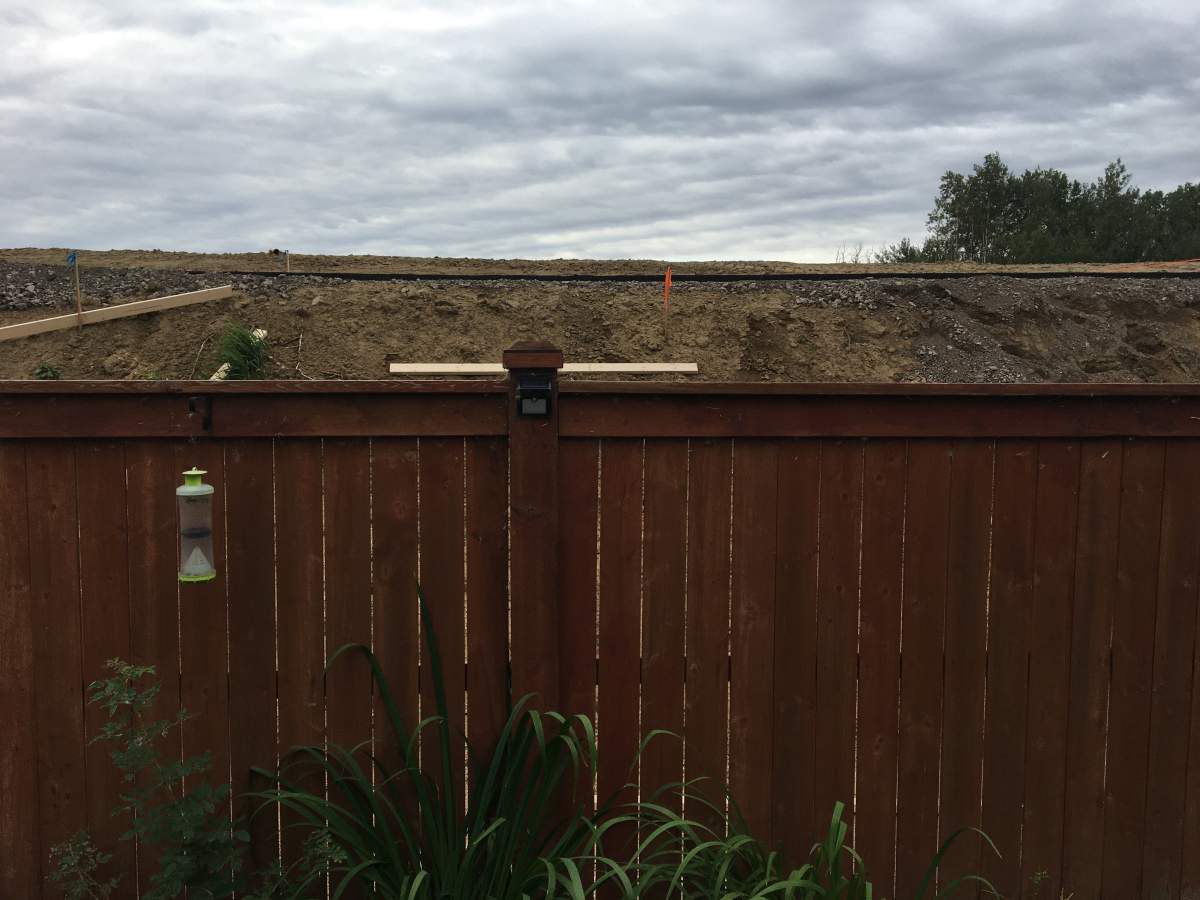 A berm that is higher than backyard fences in the west Edmonton community in Secord also has a public path built on it.