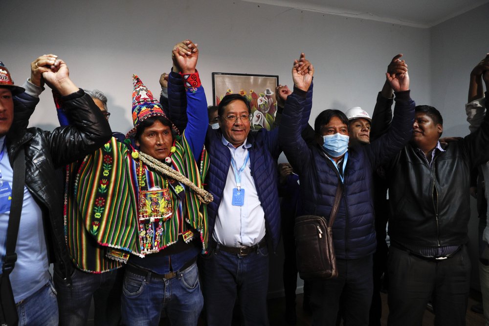 Luis Arce, center, Bolivian presidential candidate for the Movement Towards Socialism Party, MAS, and running mate David Choquehuanca, second right, celebrate during a press conference where they claim victory after general elections in La Paz, Bolivia, Monday, Oct. 19, 2020.