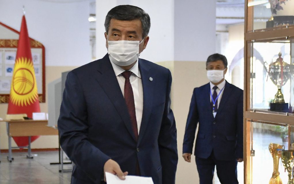 Kyrgyzstan's President Sooronbai Jeenbekov wearing a face mask casts his ballot paper during parliamentary elections in Bishkek, Kyrgyzstan, Sunday, Oct. 4, 2020. 