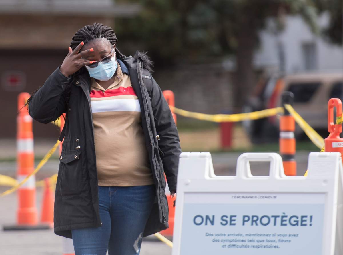 A woman waits to be tested for COVID-19 at a testing clinic in Montreal, Sunday, October 4, 2020, as the COVID-19 pandemic continues in Canada and around the world. 