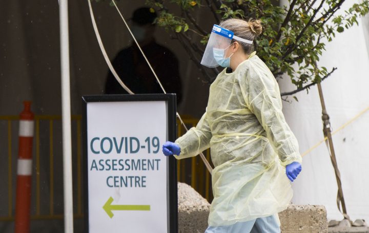 A medical worker wearing protective gear is seen outside a COVID-19 assessment centre in Toronto on Oct. 15, 2020.