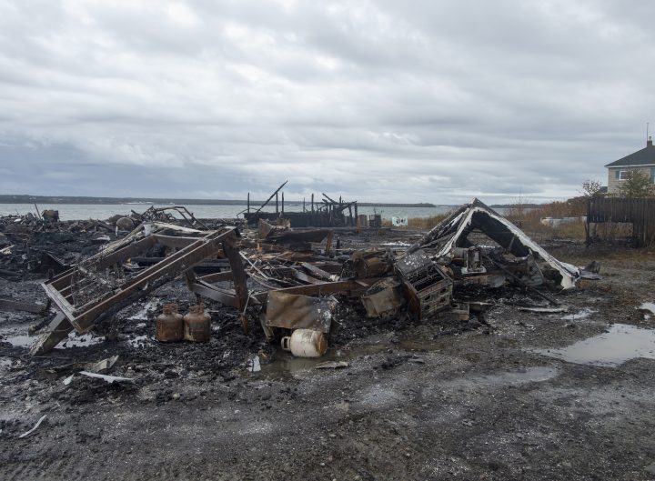 Debris from a burnt out fish plant is scattered along the shore in Middle West Pubnico, N.S. on Saturday, Oct. 17, 2020.