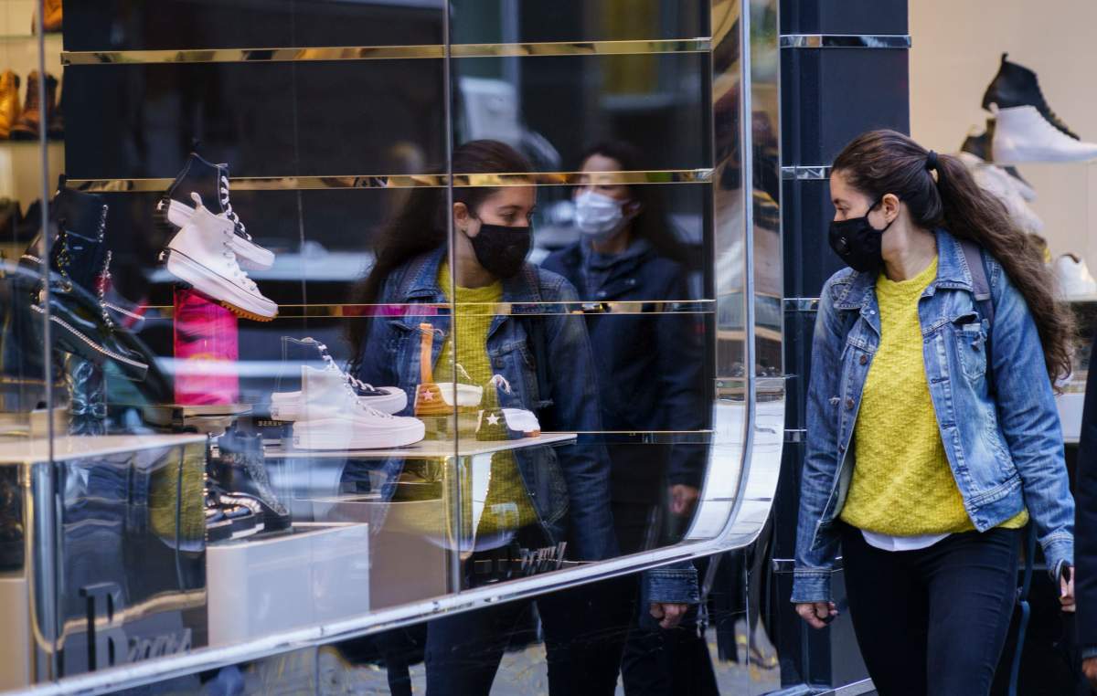 A woman does a bit of window shopping along Montreal's Sainte-Catherine Street, on Tuesday, Oct. 20, 2020. 