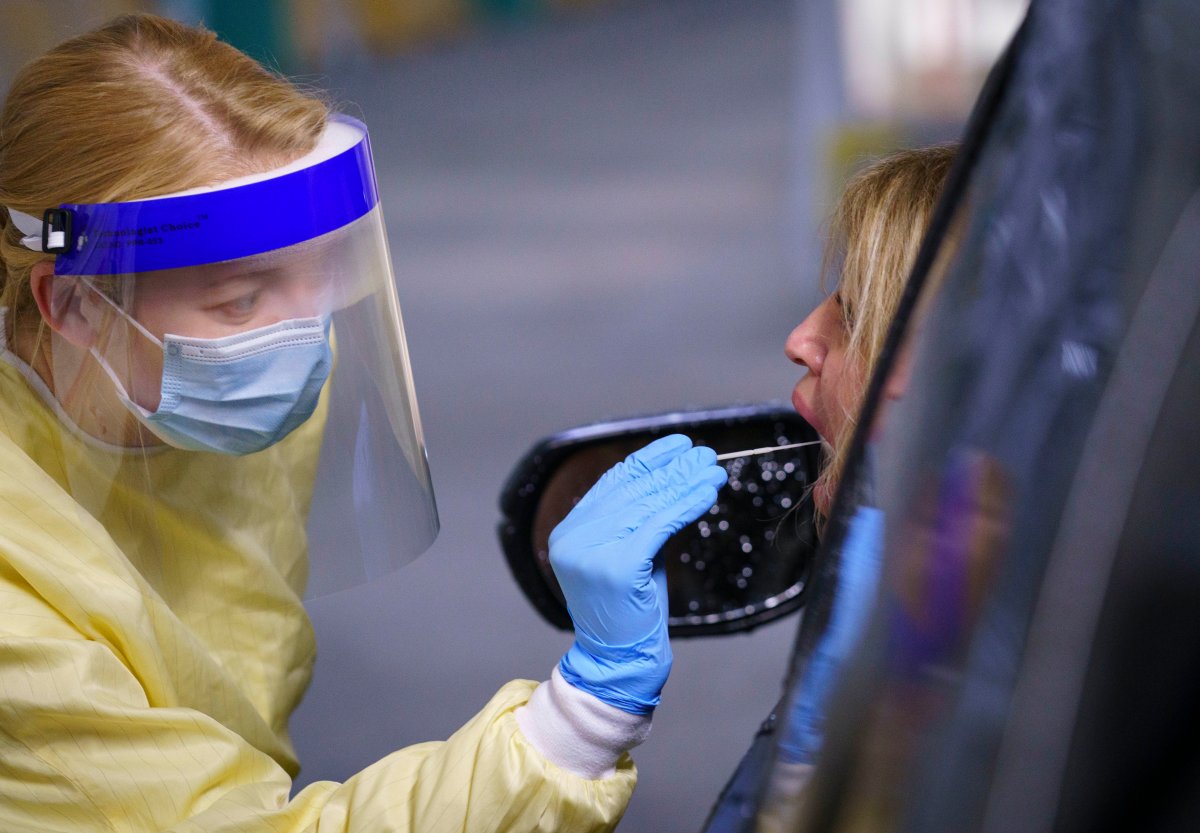 A nurse performs a test on a patient at a drive-in COVID-19 clinic in Montreal, on Wednesday, October 21, 2020. 