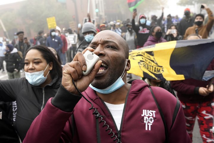 Rayon Edwards speaks on a megaphone as he marches with protesters during a protest rally for Marcellis Stinnette who was killed by Waukegan Police Tuesday in Waukegan, Ill., Thursday, Oct. 22, 2020. Stinnette, 19, was killed and his girlfriend the mother of his child, Tafara Williams, was wounded when a police officer in Waukegan opened fire Tuesday night after police said Williams' vehicle started rolling toward the officer following a traffic stop. 