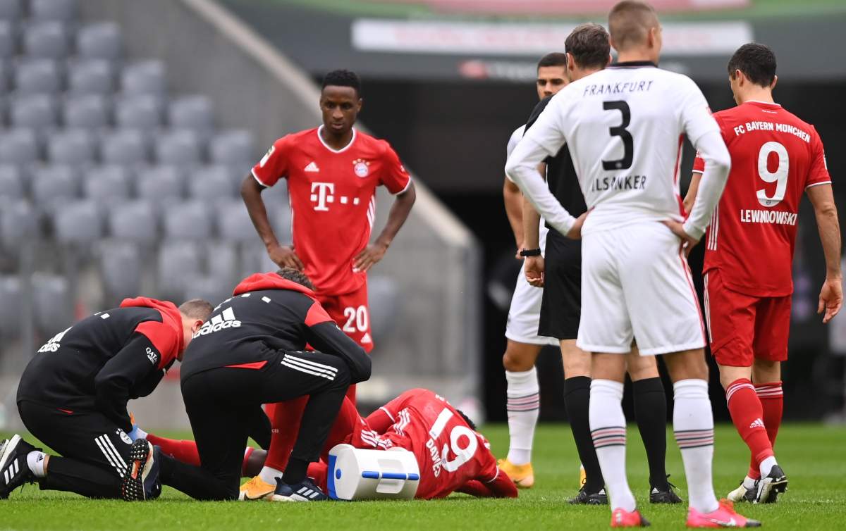 Bayern's Alphonso Davies (aground) receives medical attention during the German Bundesliga soccer match between FC Bayern Munich and Eintracht Frankfurt, in Munich, Germany, 24 October 2020. 
