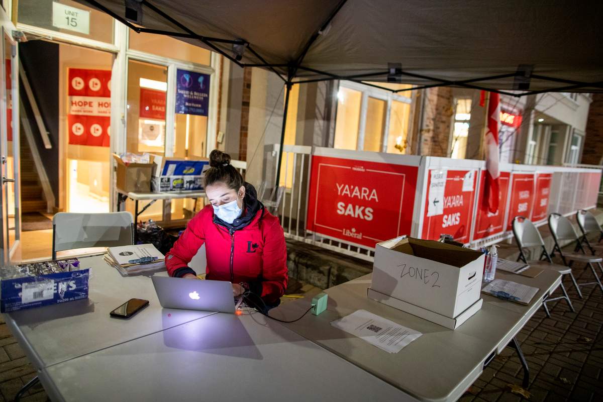 A volunteer is seen outside the campaign office of Liberal candidate YaÕara Saks in the York Centre riding before the polls close in the federal by election in Toronto on Monday, October 26, 2020. 
