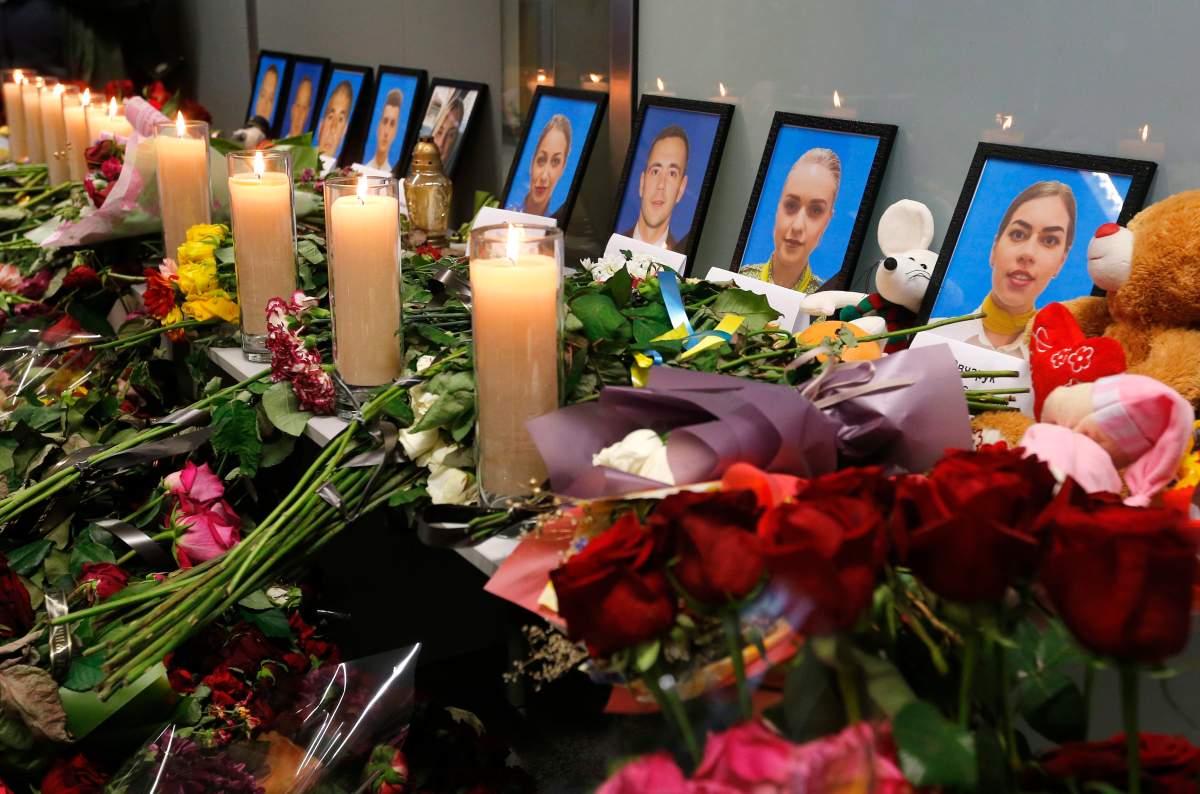 Flowers and candles are placed in front of portraits of the flight crew members of the Ukrainian 737-800 plane that crashed on the outskirts of Tehran, at a memorial inside Borispil international airport outside Kyiv, Ukraine, Saturday, Jan. 11, 2020. 