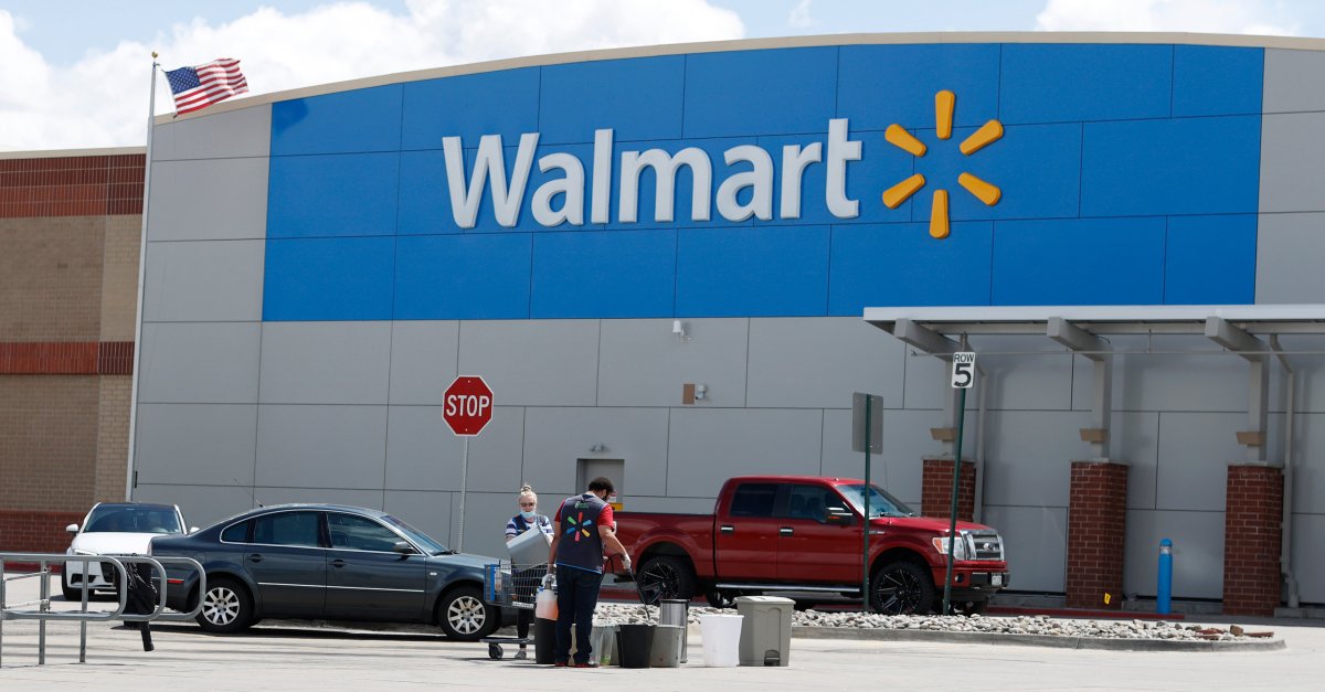 Workers sanitize items outside a Walmart that has been closed following the deaths of three people connected to the store after they were infected with the new coronavirus and at least six more employees have tested positive for COVID-19, Friday, April 24, 2020, in Aurora, Colo.