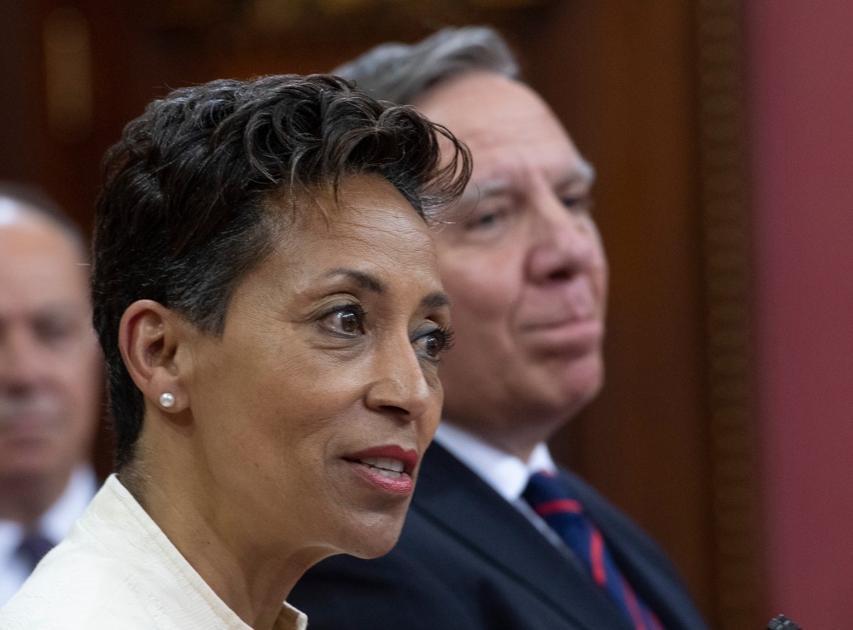 Nadine Girault, Minister of Immigration, Diversity and Inclusiveness,responds to reporters questions after Quebec Premier Francois Legault, right, announced a cabinet shuffle, Monday, June 22, 2020 at the legislature in Quebec City. 