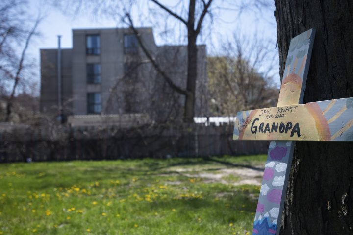 A cross in memory of a former resident rests against a tree near the Camilla Care Community, a long-term care home in Mississauga, Ont., on April 13, 2020. 