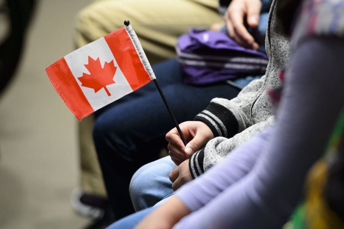 A young new Canadian holds a flag as she takes part in a citizenship ceremony on Parliament Hill in Ottawa on Wednesday, April 17, 2019, to mark the 37th anniversary of the Canadian Charter of Rights and Freedoms. A report by the Royal Bank says a slowdown of immigration to Canada due to the COVID-19 pandemic threatens to derail what it says has been a major source of economic growth at least temporarily. THE CANADIAN PRESS/Sean Kilpatrick.