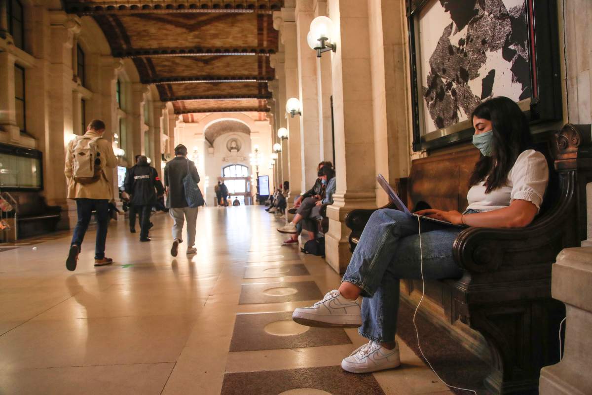 A student of the Pantheon university wearing a face mask to prevent the spread of coronavirus works on her computer at the entrance hall in Paris, Thursday, Sept. 24, 2020.