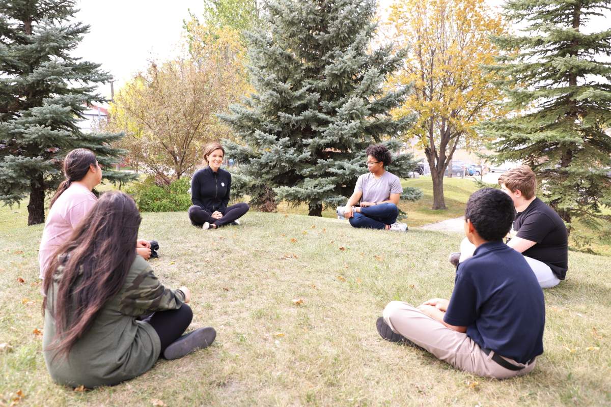 Project 11's Suzi Friesen, centre left, does socially distanced meditation work with students during COVID-19. The True North Youth Foundation program has increasingly turned to technology to continue its work through the pandemic.