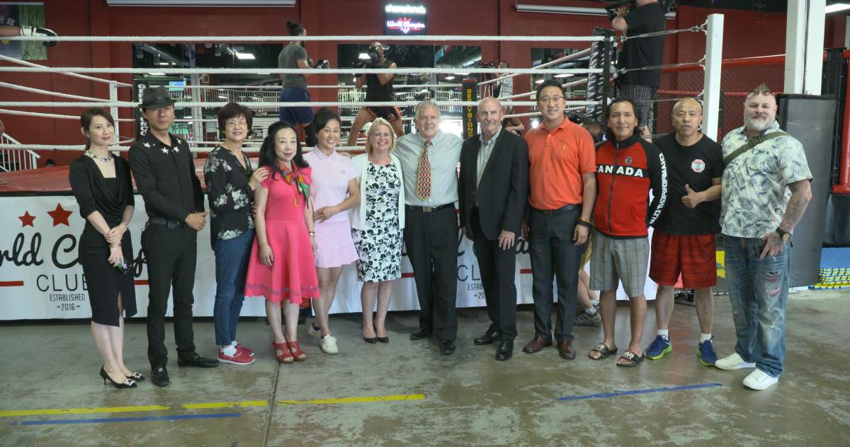 NDP Minister Lisa Beare poses with Paul King Jin (bald man second from right) and others at Warrior Fighting Dream gym, in 2019.