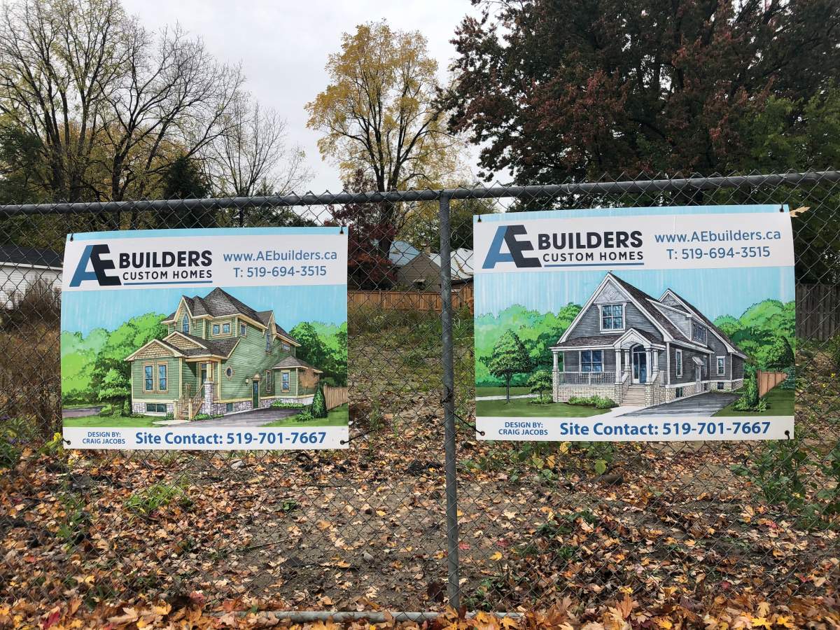 Graphic renderings sit on a fence surrounding a plot of land that used to house three homes on Woodman Avenue.
