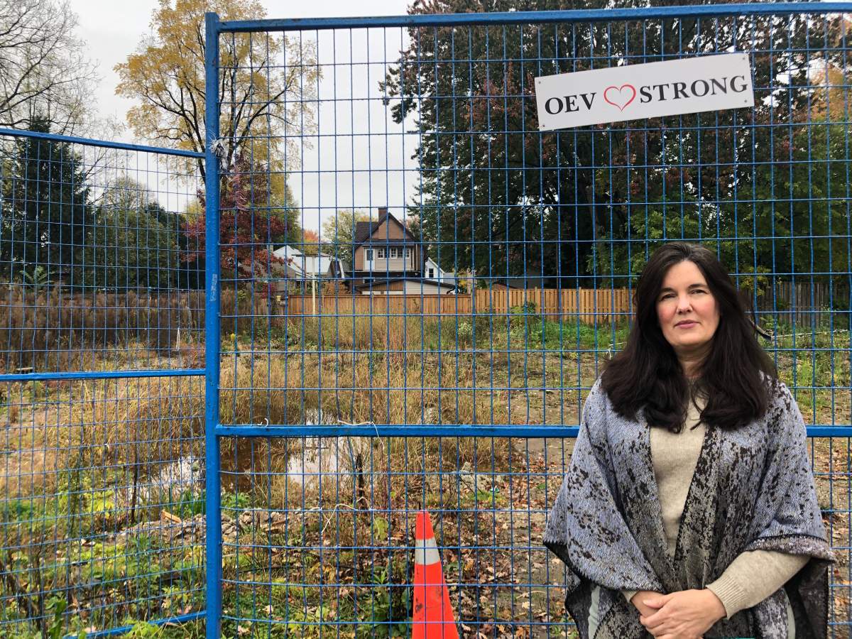 Karen Fisher stands in front of the empty lot where her Woodman Avenue home used to be. Last year's explosion in Old East Village saw the house completely destroyed.