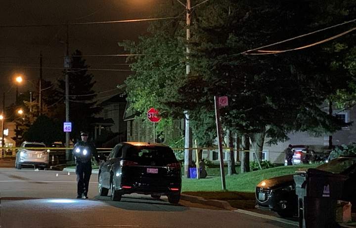 An officer searches for evidence as two officers (right) examine the vehicle where the victim was found.