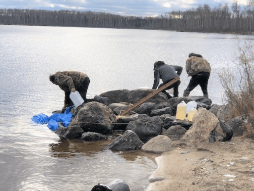 Neskantaga residents gather water from a lake amid an ongoing water crisis.