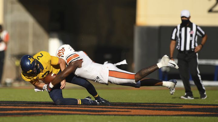 Oklahoma State linebacker Amen Ogbongbemiga (7) tackles West Virginia quarterback Jarret Doege (2) during an NCAA college football game Saturday, Sept. 26, 2020, in Stillwater, Okla. 