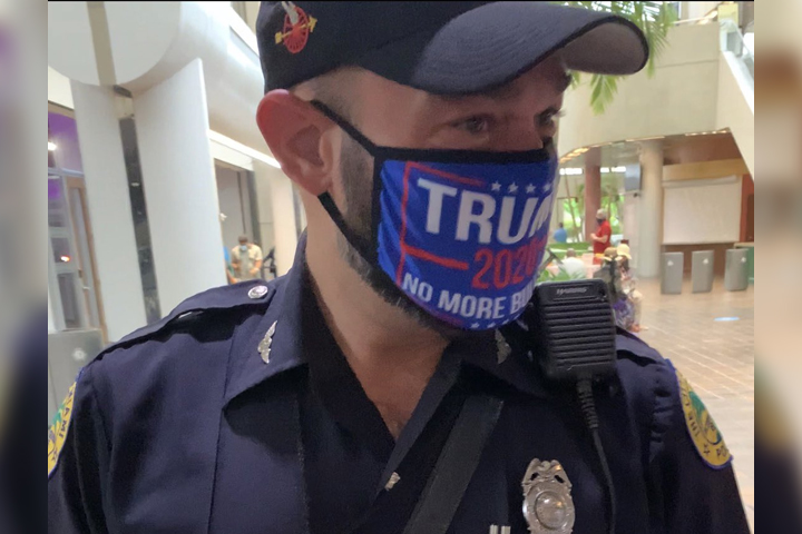 A police officer is shown wearing a pro-Trump mask at the Stephen P. Clark Government Center in Miami on Oct. 20, 2020.