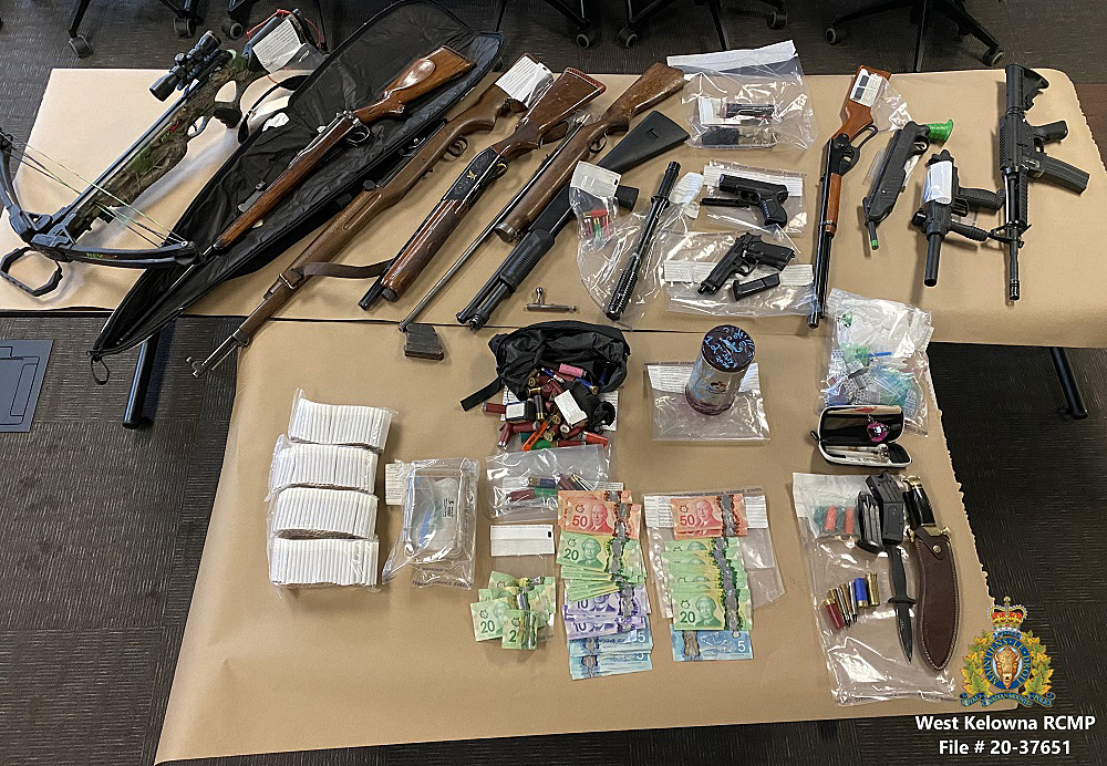 A police photograph showing the firearms, drugs and cash that were seized from a West Kelowna home this week.