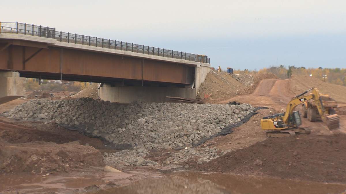 Workers continue to construct a bridge that was previously delayed. The bridge is now expected to open in November 2021.