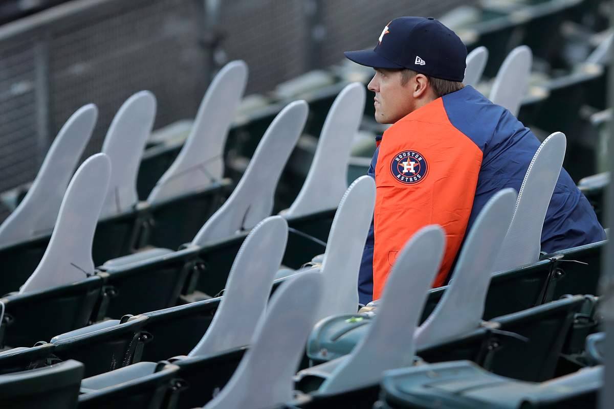 Houston Astros pitcher Zack Greinke socially distances himself beside cardboard cutout fans in the stands of the Oakland Coliseum in the fourth inning of a baseball game against the Oakland Athletics on Friday, Aug. 7, 2020, in Oakland, Calif.