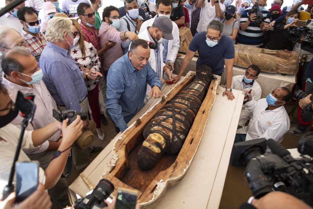 Khaled El-Anaby, Minister of Tourism and Antiquities, right, and Mostafa Waziri, the secretary-general of the Supreme Council of Antiquities, left, react after opening the sarcophagus is around 2,500 years old at the Saqqara archaeological site, south of Cairo, Egypt, Saturday, Oct. 3, 2020.